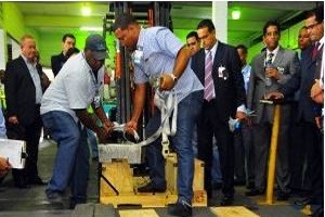 Empleados de la Dirección General de Aduanas cargan una de las ocho barras de doré (mezcla de oro y plata) para pesarla delante de ejecutivos de la institución