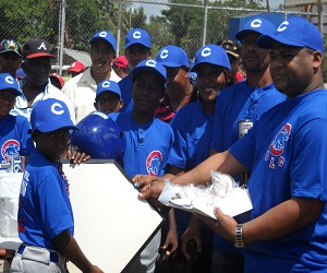 En el extremo derecho, el director del Distrito Municipal La Cuaba, hace entreg a de los útiles