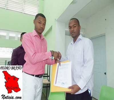 Félix de la Rosa (Hansell), presidente saliente, hace entrega de los documentos de la organización al nuevo titular de ASEUPEB,Jeffrey Sánchez Mena.