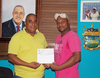 Rafael Acevedo, de la Federación, recibiendo los RD$100 mil