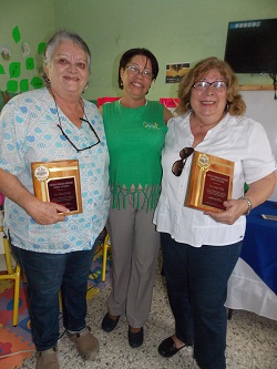 Las dos reconocidas con la directora del plantel en el centro.
