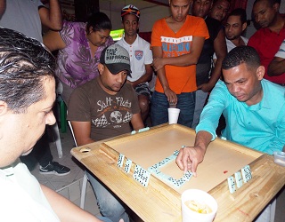 En el margen derecho con camisa verde, el Campeón Mundial de Dominó